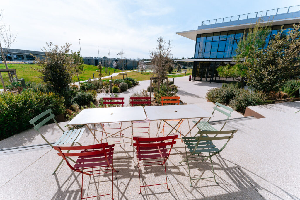 Outdoor seating area with colorful chairs, promoting a collaborative work environment at Voyage Privé.